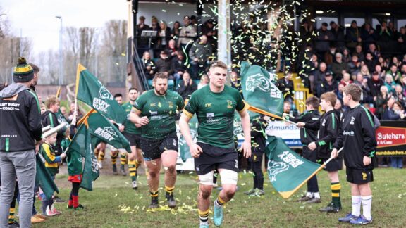 Rugby players running onto the pitch